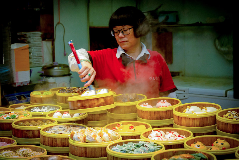 A photo of a lady who is serving Chinese Dim Sum