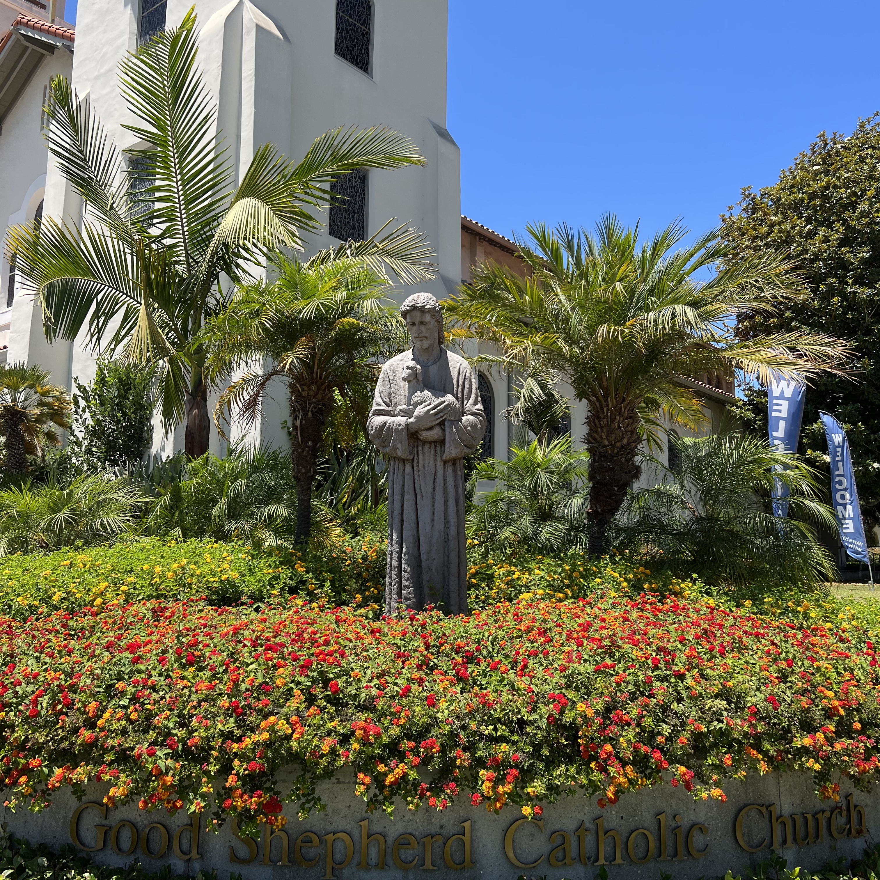 A church and a statue surrounded by plants