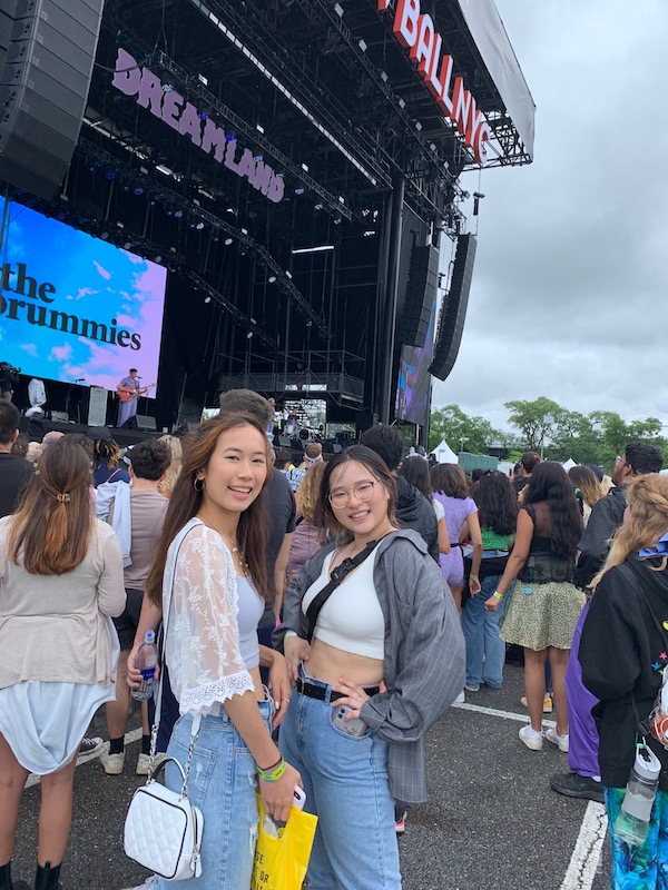 Two girls in front of a outdoors concert stage