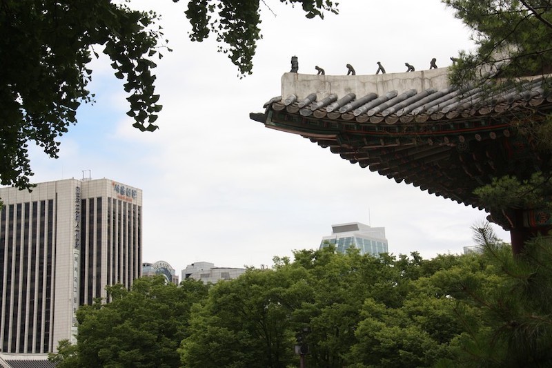 Korean temple roof overaching the background of modern buildings
